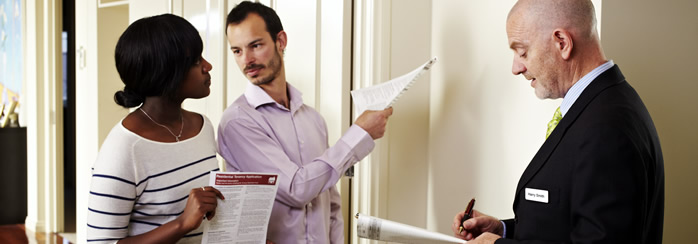 A couple inspecting a rental property with a real estate agent.