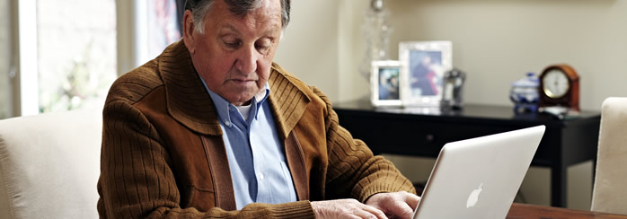 Retiree typing on a laptop 